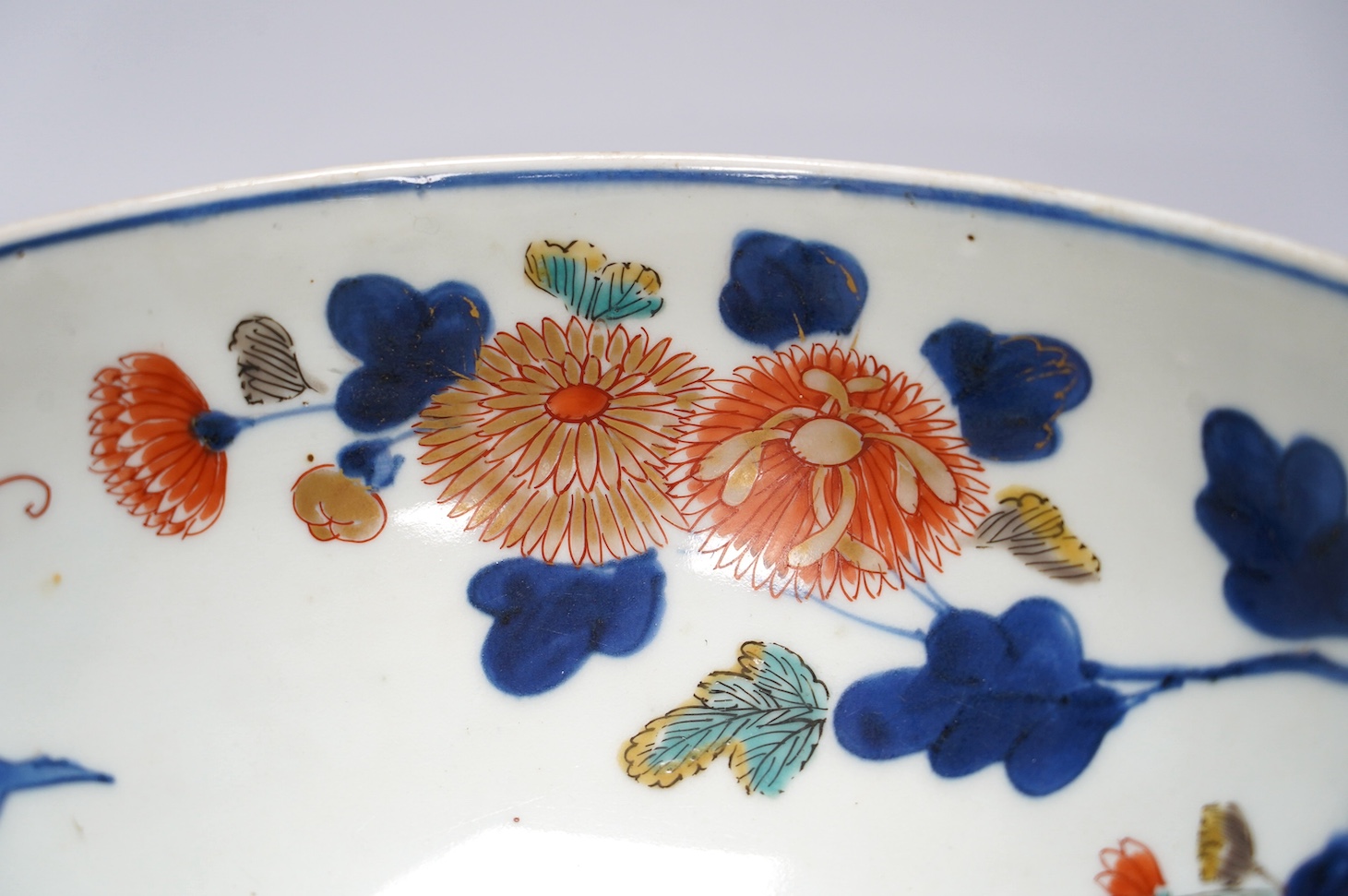 A Japanese Arita polychrome bowl, c.1700, diameter 24.5cm, height 12.5cm, on a carved hardwood stand. Condition - large overglazed open firing crack to foot, otherwise good